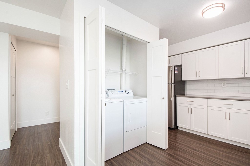 A white laundry room with a washer and dryer at The Crossings Apartments, Grand Rapids, MI, 49508