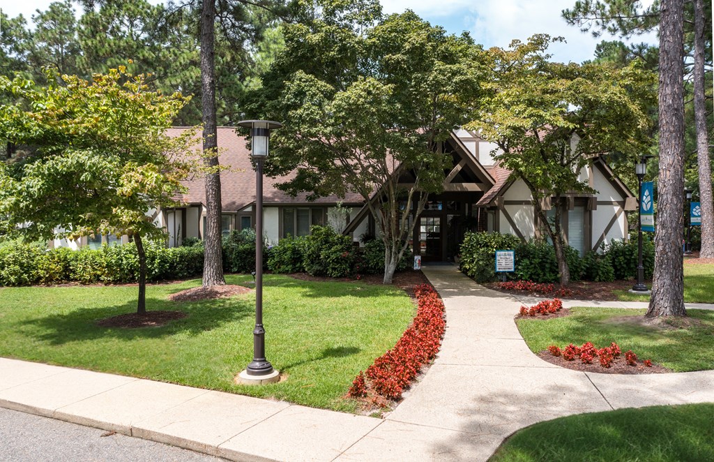 A house with a brown roof and a green lawn.