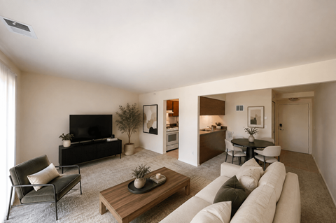 A living room with a white couch and a wooden coffee table.