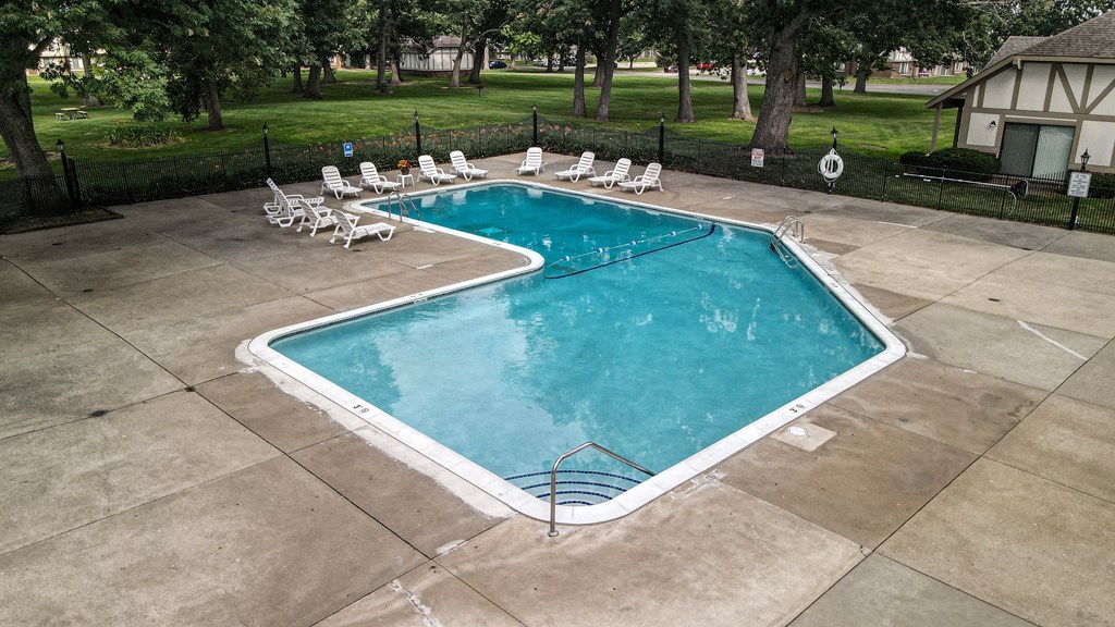 a swimming pool with chaise lounge chairs and trees in the background at Beacon Hill and Great Oaks Apartments, Illinois, 61109