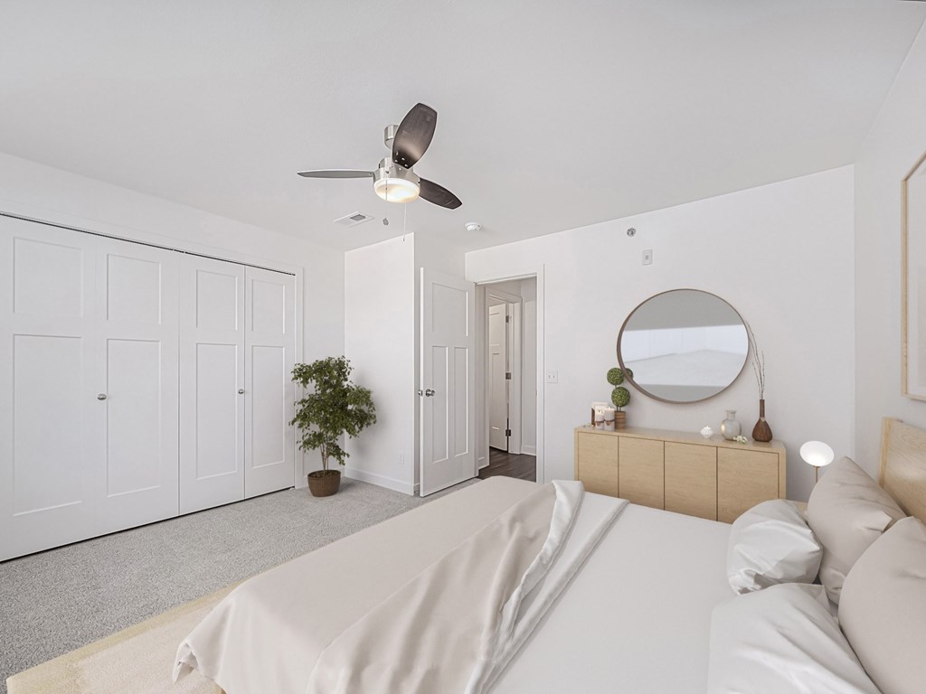 A bedroom with a bed, dresser, mirror, and a ceiling fan at Dodson Pointe Apartment Homes, Rogers