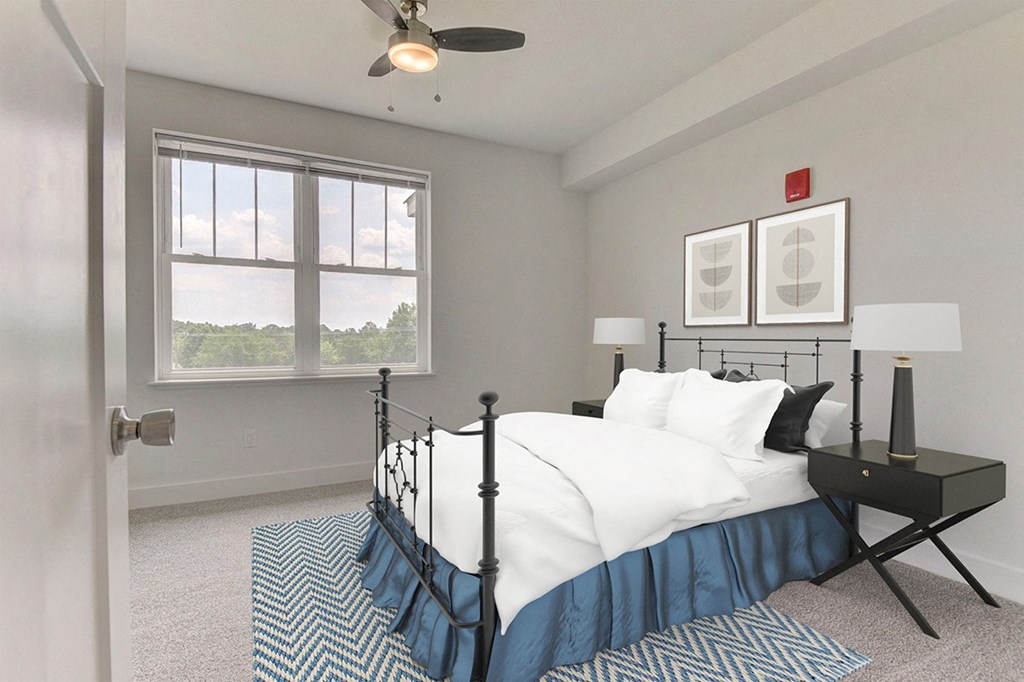 A bedroom with a bed, nightstand, ceiling fan and a window at Dodson Pointe Apartment Homes, Rogers