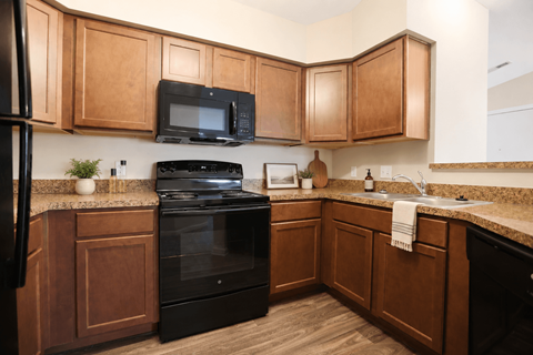 A kitchen with wooden cabinets and black appliances.