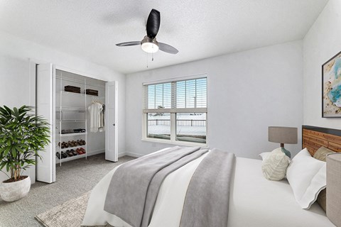 A bedroom with a large bed and a walk in closet with organizers at Eagle Ridge Apartment Homes, Traverse City, MI 49685