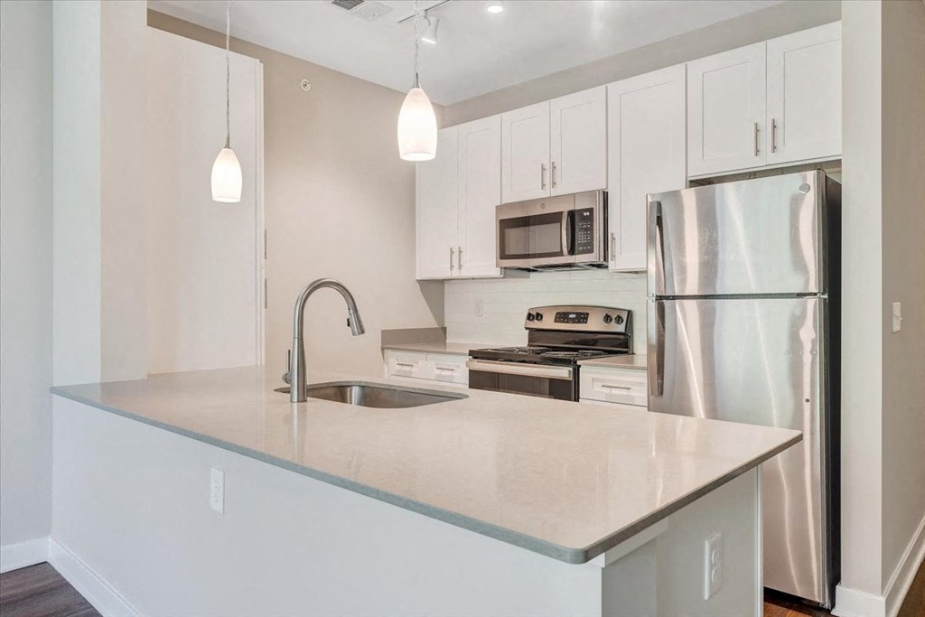 a kitchen with a counter top and a stainless steel refrigerator