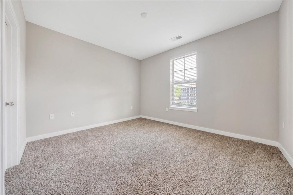 an empty room with carpet and a window