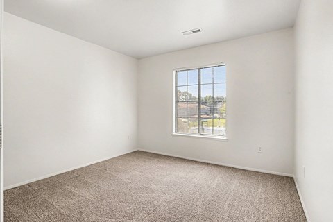 Empty bedroom with carpet and window blinds at Emerald Park Apartments, Kalamazoo, Michigan