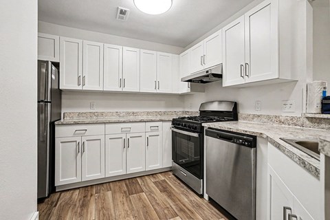 A kitchen with white cabinets and stainless steel appliances.