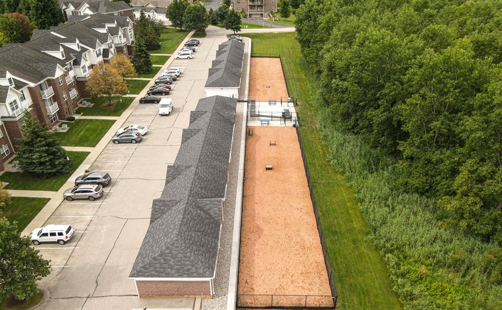 A long parking lot with cars parked in it.