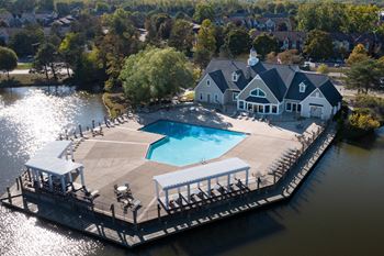 A large house with a pool is surrounded by water.