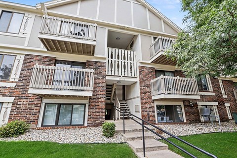 A multi-story apartment building with a balcony on the second floor.