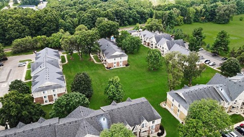 A bird's eye view of a residential area with houses and green lawns.