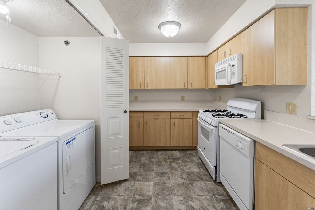 A kitchen with a washer and dryer, microwave and dishwasher at Fieldstream Apartment Homes, Iowa