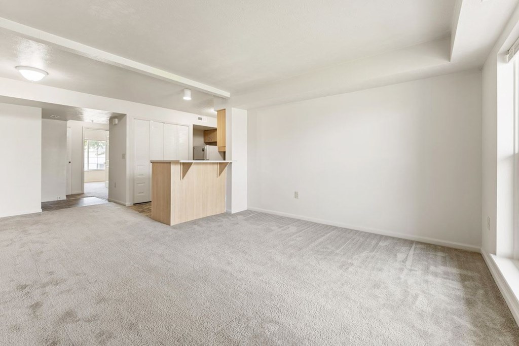 A large, empty living room with a carpeted floor at Fieldstream Apartment Homes, Iowa