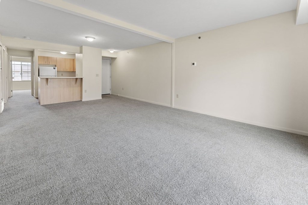 A large, empty dining room with a grey carpet at Fieldstream Apartment Homes in IA 50023
