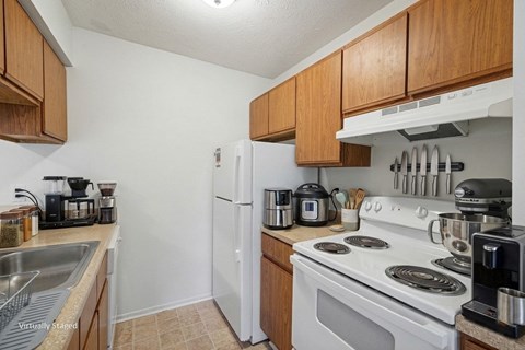 A kitchen with a white stove top oven and a white refrigerator.