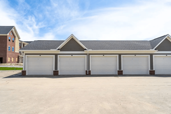 a car garage with three garages and a house in the background at 24 at Bloomfield, Bloomfield Township, MI, 48302