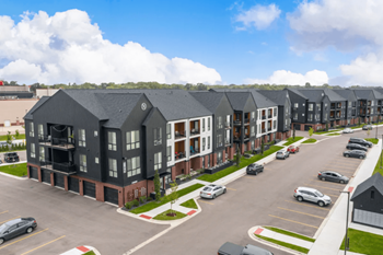 an aerial view of a row of apartment buildings in a parking lot  at Uptown Square Apartments, Troy, 48083