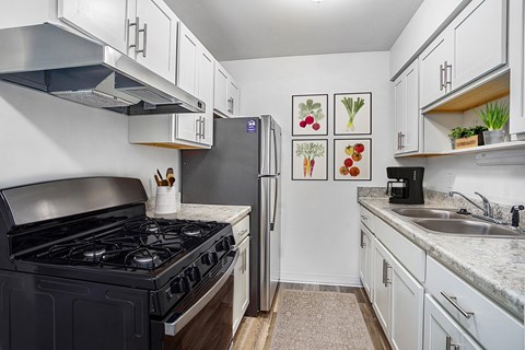 A kitchen with a black stove top and a refrigerator.