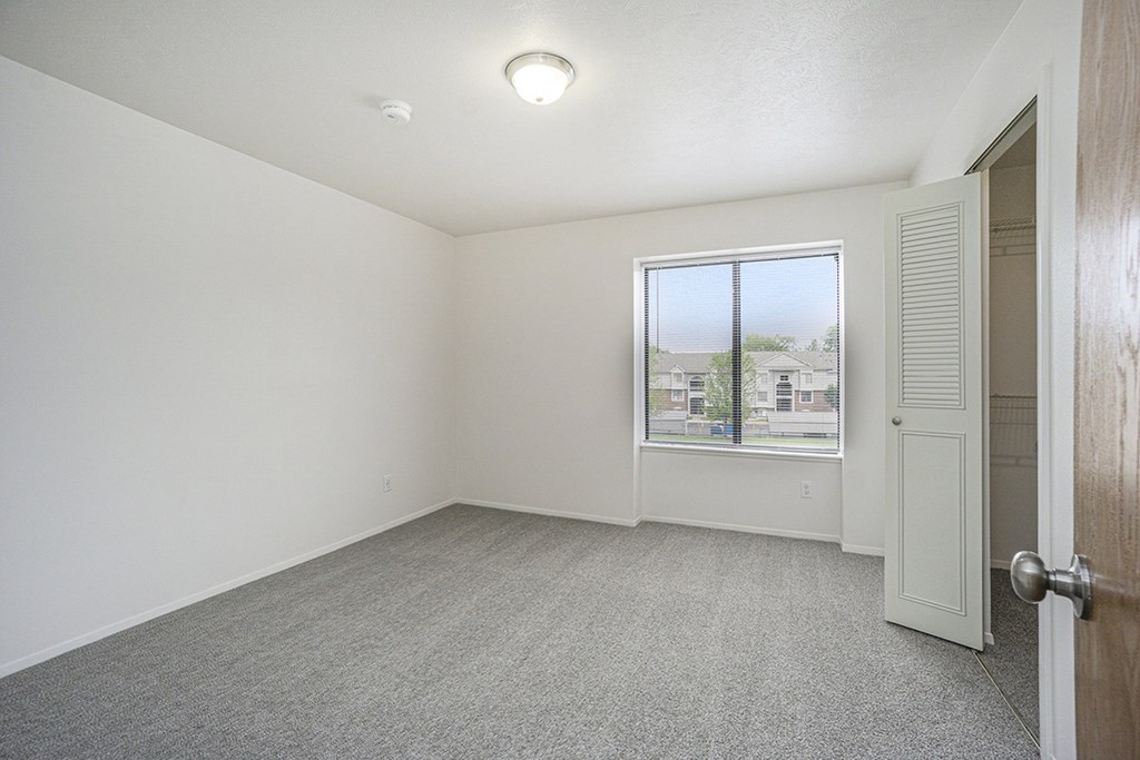 Bedroom with a closet and a window at Glenn Valley Apartments, Battle Creek