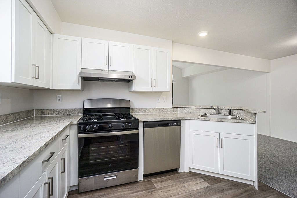 A kitchen with a stove, a dishwasher and breakfast bar at Glenn Valley Apartments, Battle Creek, MI, 49015