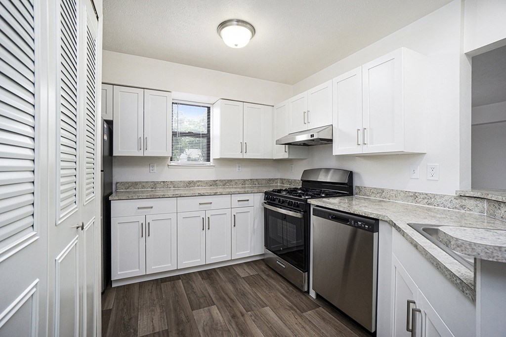 A kitchen with white cabinets and a stainless steel dishwasher and oven at Glenn Valley Apartments, Battle Creek, MI, 49015
