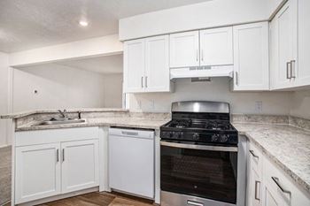 a kitchen with white cabinets and hard surface flooring at Glenn Valley Apartments in Battle Creek, MI