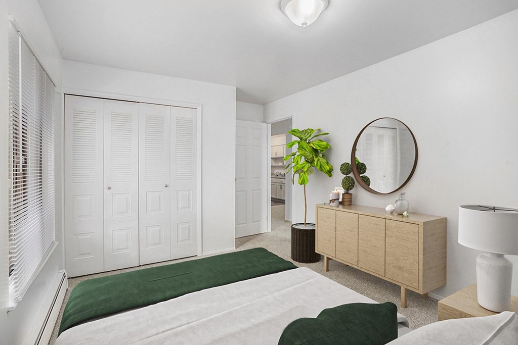An upgraded bedroom with a closet and plush carpeting at Granada Apartments, Jackson, 49202