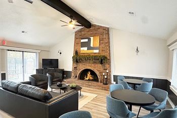 A community room with a fireplace and a television at Granada Apartments in Jackson, MI