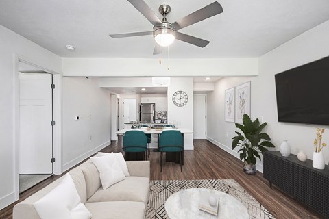 A living room with a white couch and a ceiling fan.