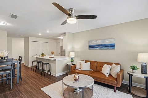 A living room with a brown couch and a ceiling fan.