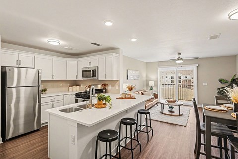 A kitchen with white cabinets and a stainless steel refrigerator.
