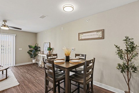 A dining room with a table set for four and a plant on the side at The Grove Apartment Homes, Nebraska