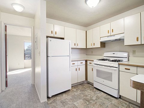 a kitchen with white appliances and white cabinets