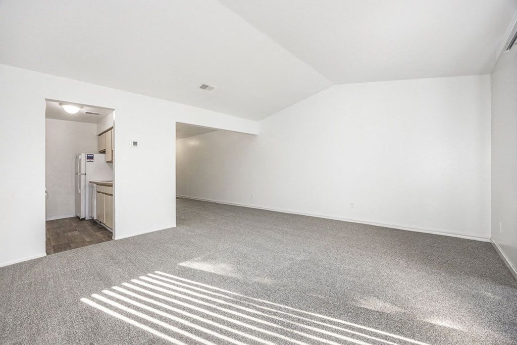 cathedral ceiling in living room with carpet at Hampton Lakes Apartments, Michigan, 49534