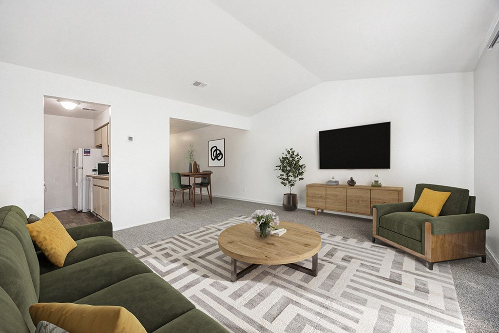 a living room with a vaulted ceiling,  couch and a coffee table at Hampton Lakes Apartments, Michigan, 49534