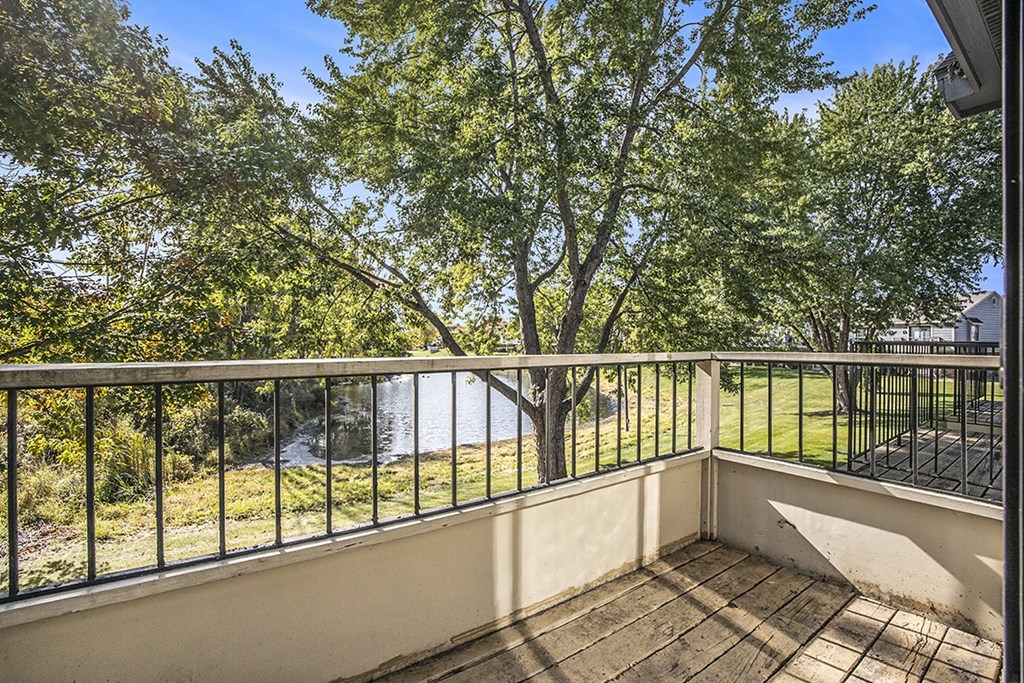 a balcony with a view of a pond and trees at Hampton Lakes Apartments, Michigan, 49534