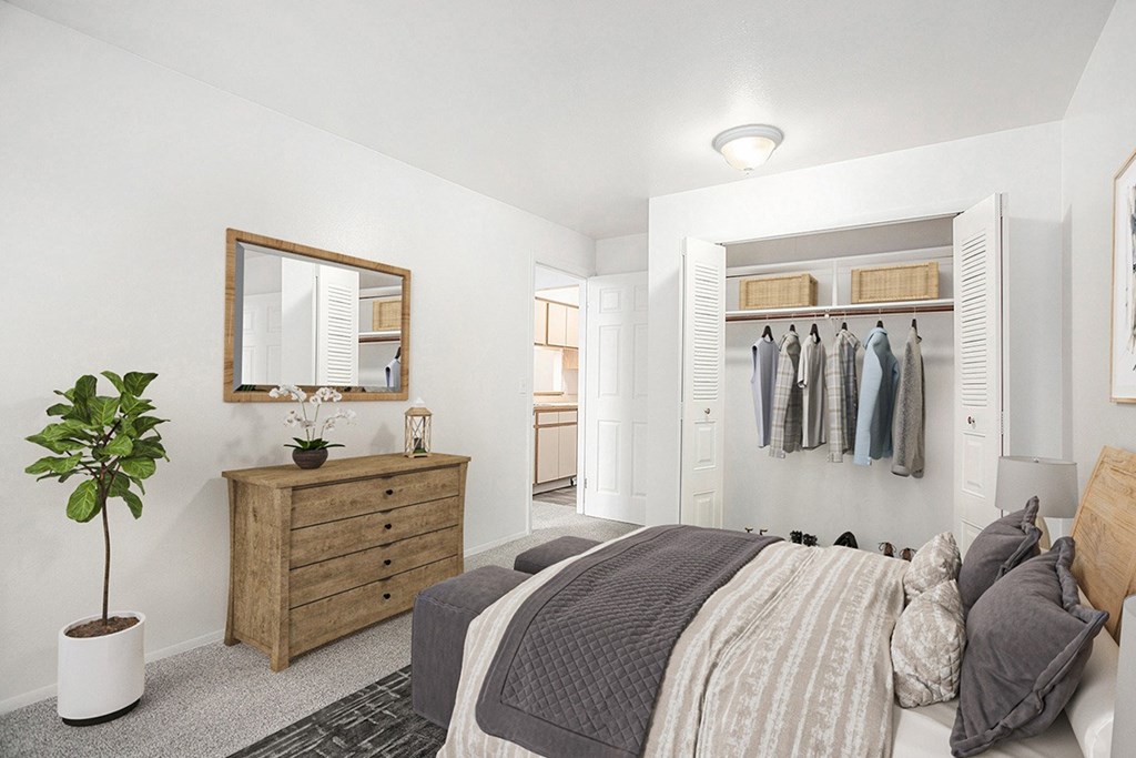 A bedroom with a bed, dresser, mirror and a closet at Hampton Lakes Apartments, Michigan, 49534