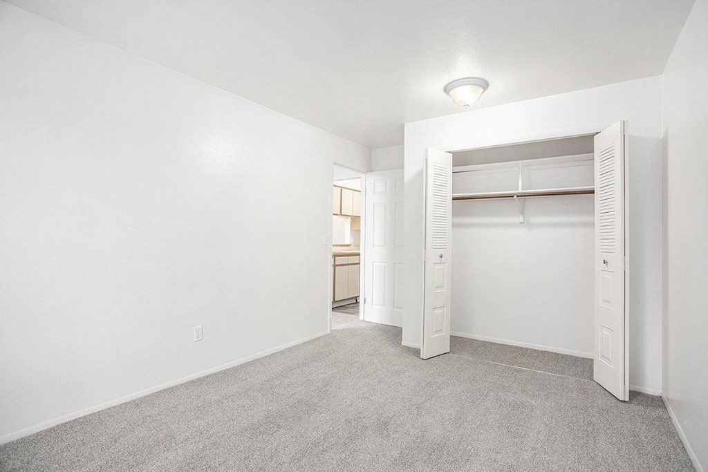 a bedroom with a closet with open doors at Hampton Lakes Apartments, Michigan, 49534