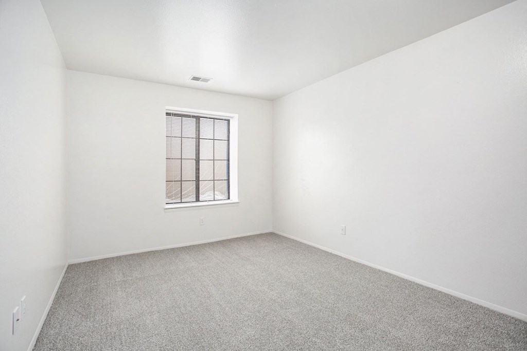 a spacious bedroom with a window at Hampton Lakes Apartments, Michigan, 49534
