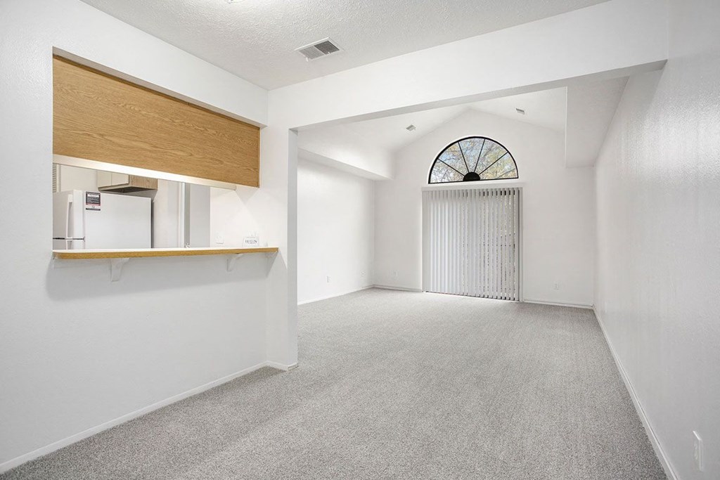 a dining and living room with a cathedral ceiling at Hampton Lakes Apartments, Michigan, 49534
