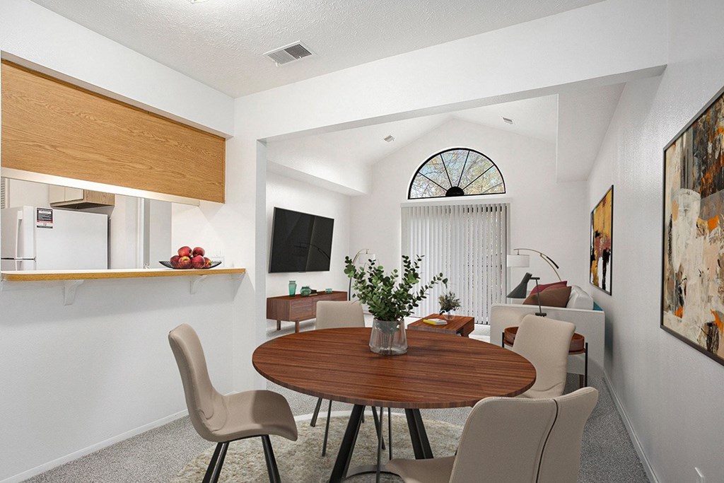 A dining room leading to a living room with a cathedral ceiling at Hampton Lakes Apartments, Michigan, 49534