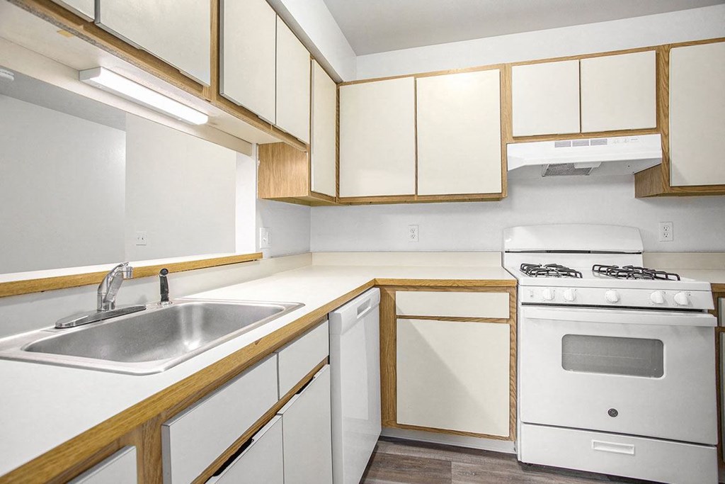a kitchen with white appliances and wooden cabinets