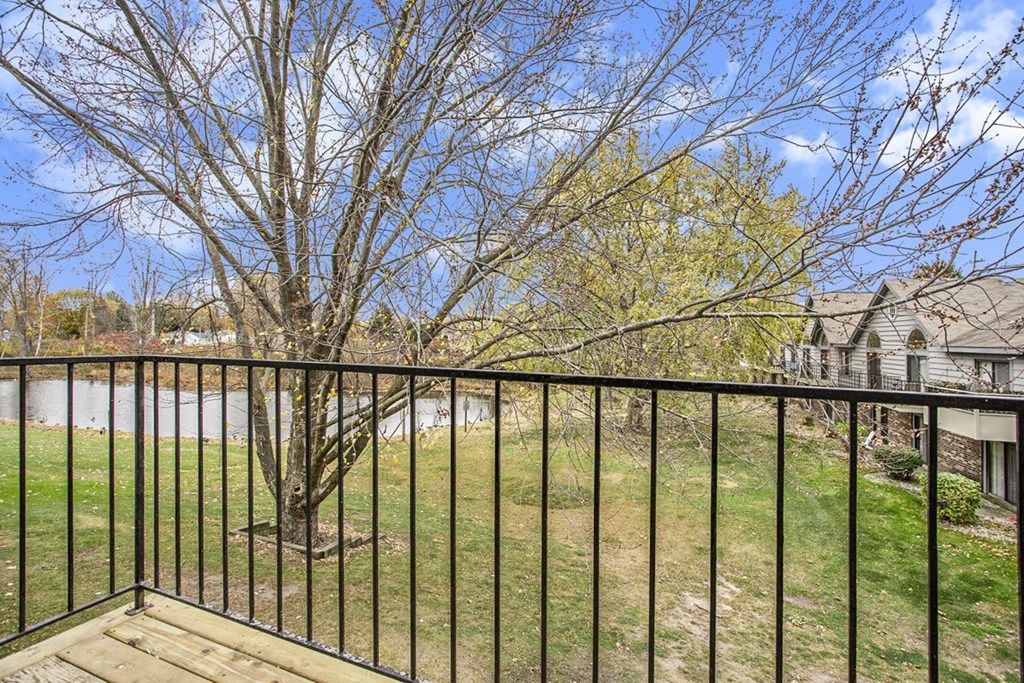 a balcony view with a tree and a pond at Hampton Lakes Apartments, Michigan, 49534