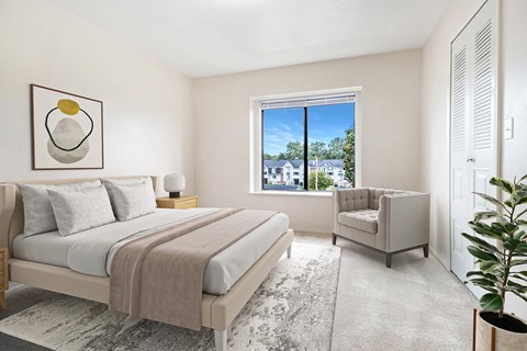 Modern bedroom with neutral decor and armchair at Hurwich Farms Apartments, South Bend