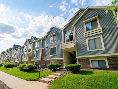 Townhome style apartment buildings with blue siding at Hurwich Farms Apartments, South Bend