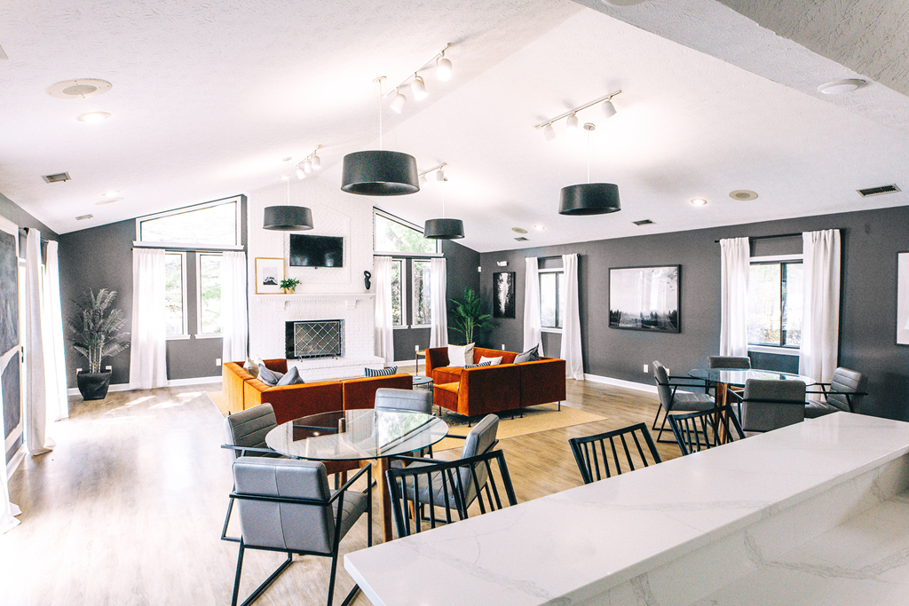 a large room with a fireplace and tables and chairs at Bavarian Village Apartments, Indiana, 46235