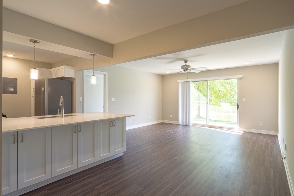 a kitchen and living room with a sliding glass door leading to a patio at Hillside Apartments, Michigan