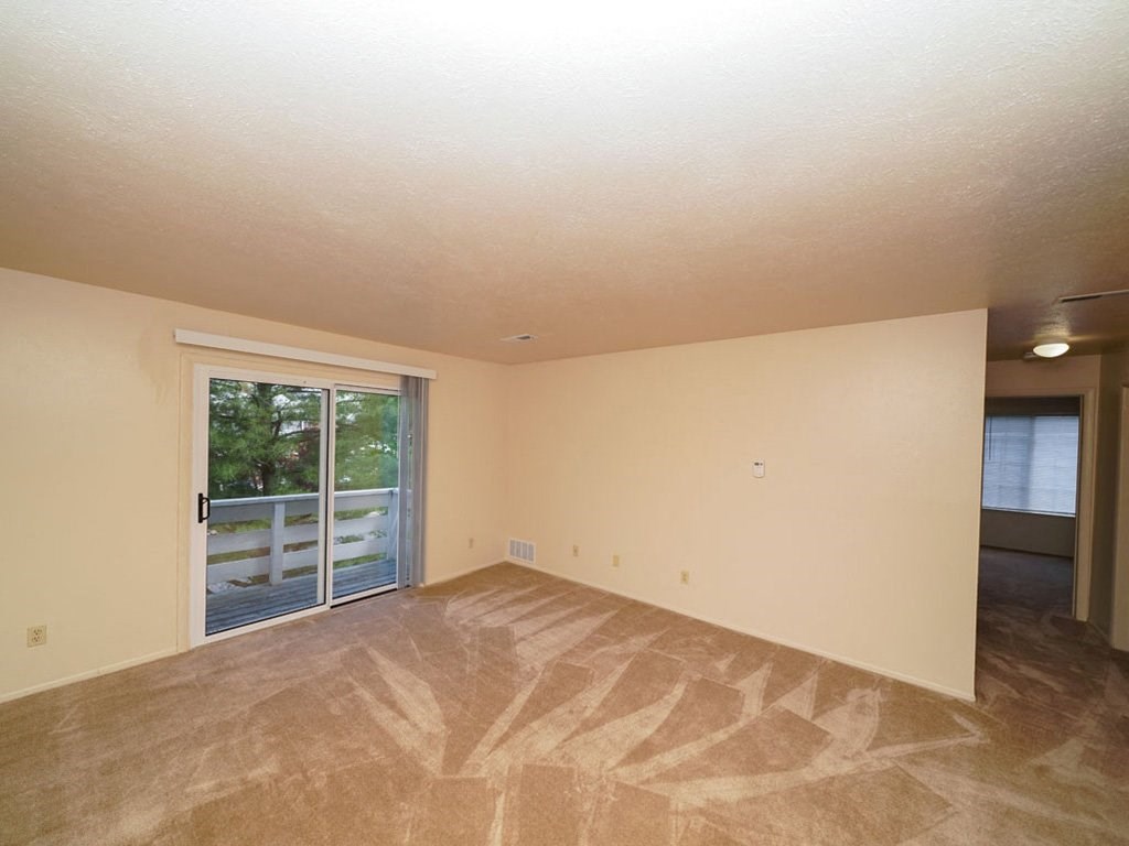 Living Room With Glass Door to Private Balcony at Irish Hills Apartments, South Bend, 46614