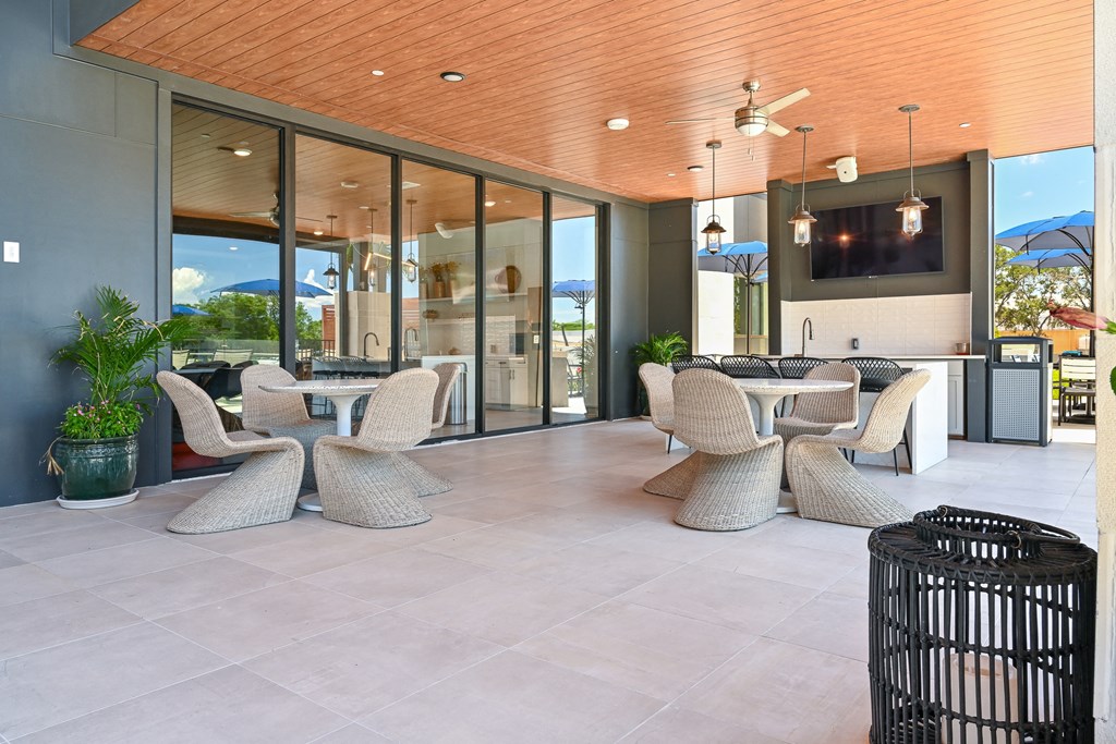a covered patio with wicker chairs and a flat screen tv at Ironwood Flats, Florida